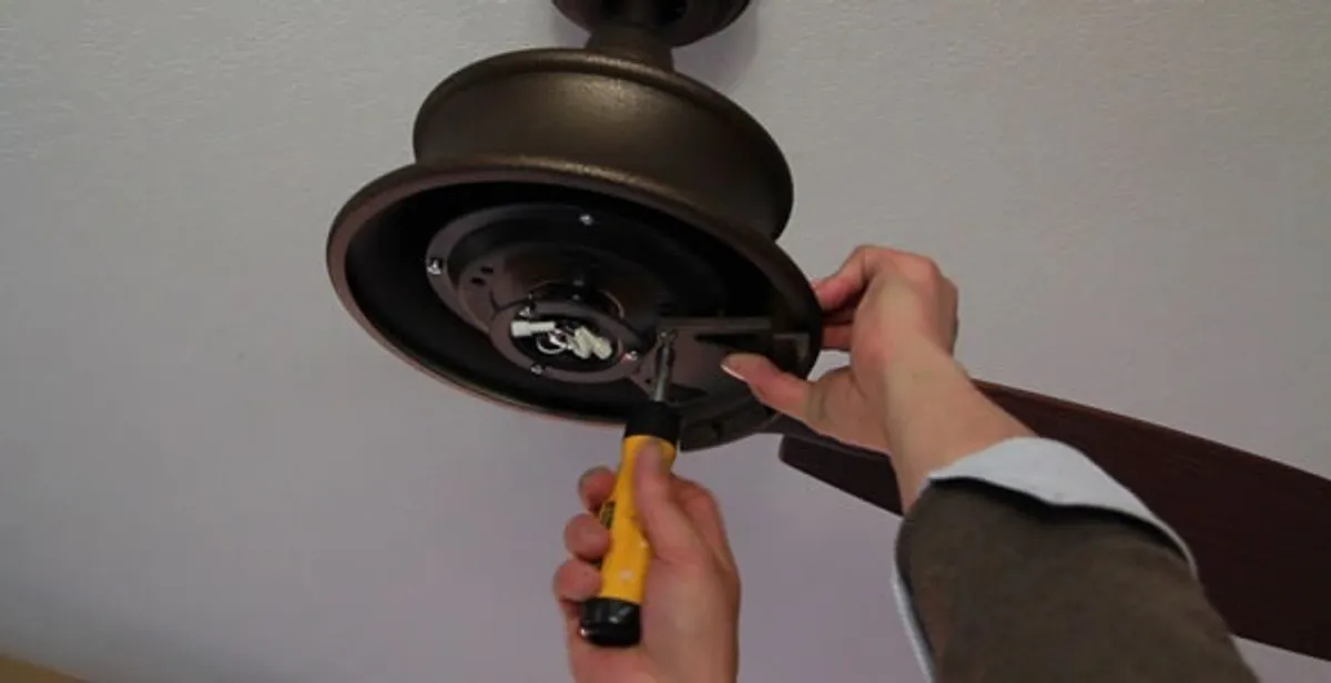 Electrician installing ceiling fan mounting bracket and fixture in Myrtle Beach, SC