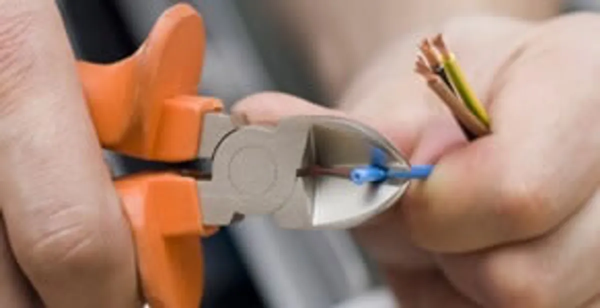 licensed electrician performing precise wire cutting and preparation during electrical service in Myrtle Beach, SC